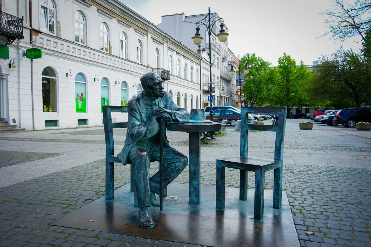 Pomnik siedzącego mężczyzny przy stoliku z kapeluszem, jedna z radomskich atrakcji.