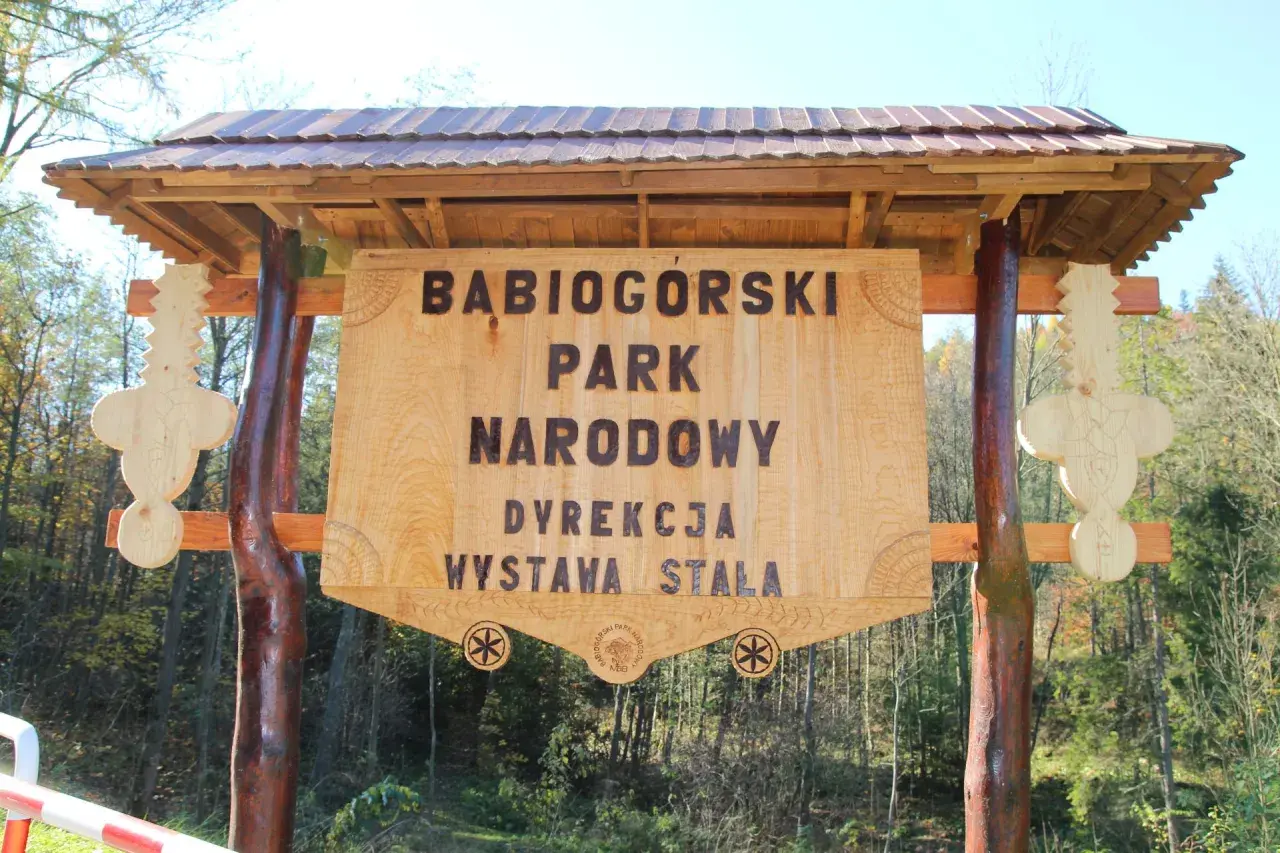 Drewniana tablica informacyjna Babiogórskiego Parku Narodowego. Zapowiada zawoja atrakcje i wystawę stałą.
