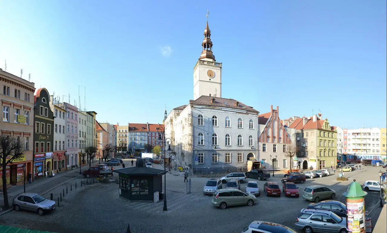 Rynek w Dzierżoniowie z ratuszem i kolorowymi kamienicami. Atrakcje miasta widoczne w słoneczny dzień.