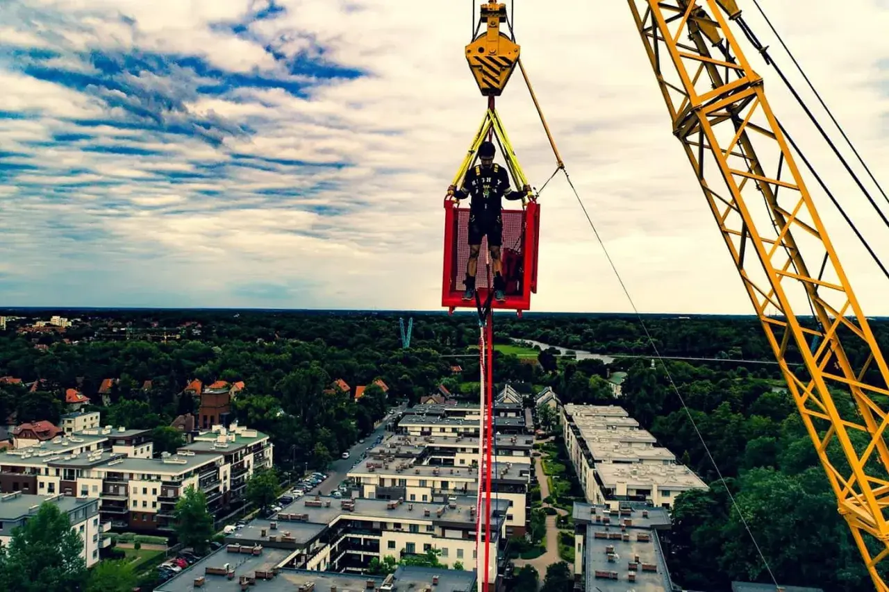 Ostatnie przygotowania przed skokiem bungee we Wrocławiu. Mężczyzna w koszu dźwigu, gotowy na adrenalinę.