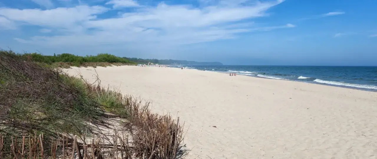 Plaża we Władysławowie, idealne miejsce na wypoczynek. Piasek, morze i zielone wydmy tworzą piękne krajobrazy, a liczne atrakcje czekają na turystów.