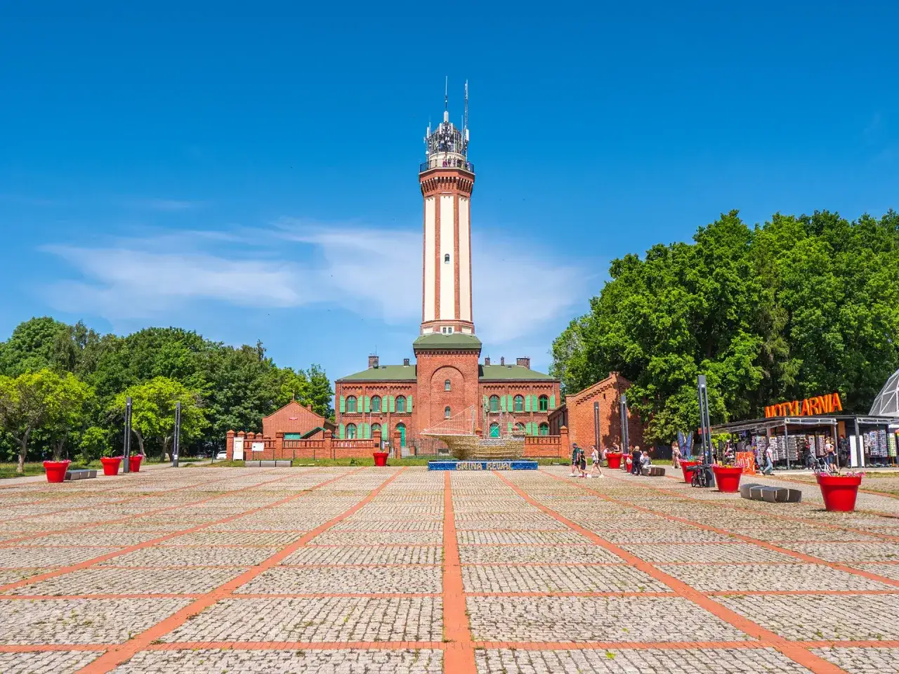Latarnia morska w Niechorzu, plac z czerwonymi donicami i budynkami, to jedne z głównych atrakcji Niechorza.