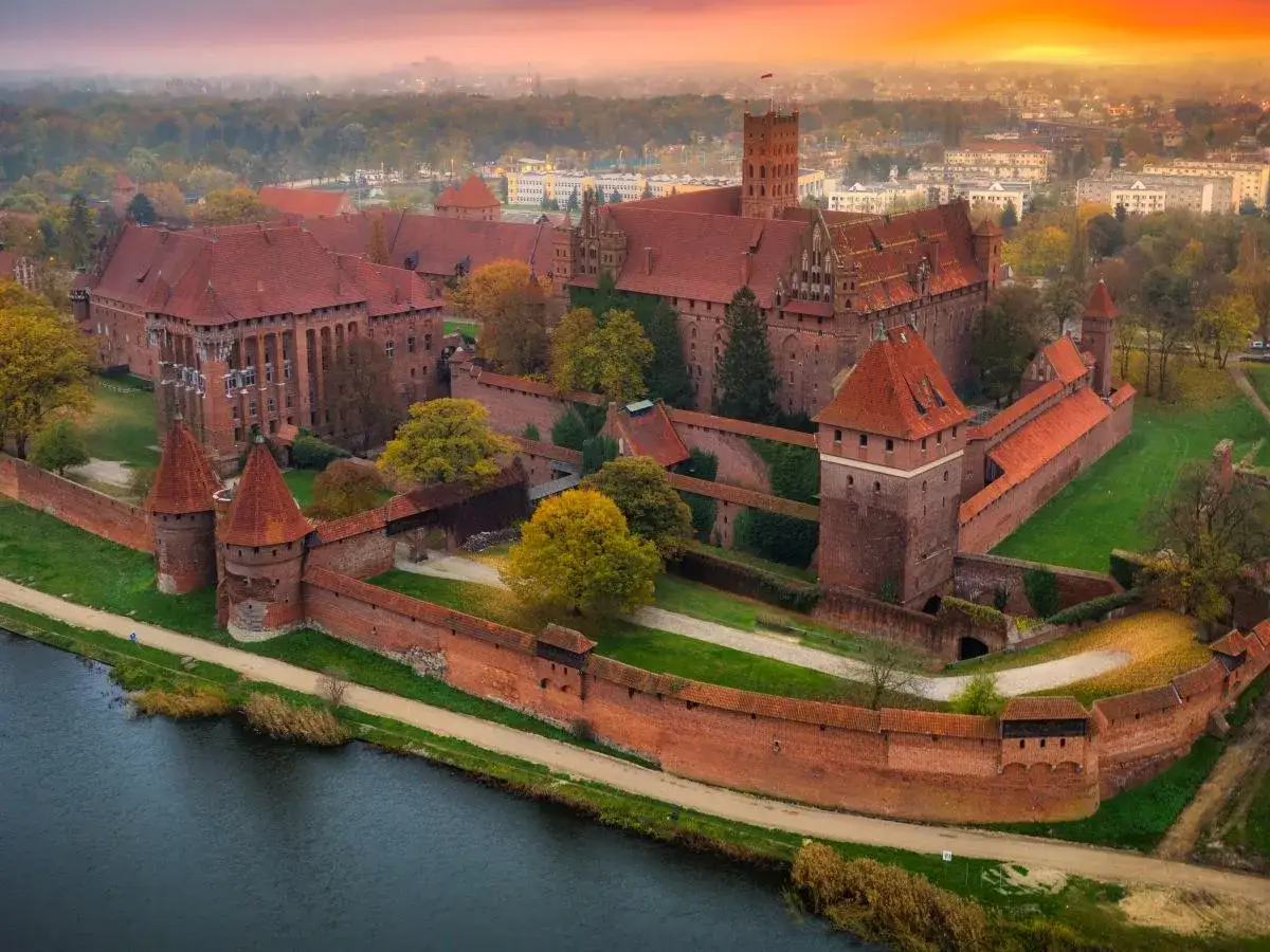 Zamek w Malborku, potężna twierdza z czerwonej cegły, otoczona murami obronnymi, to jedna z głównych atrakcji Pomorza.