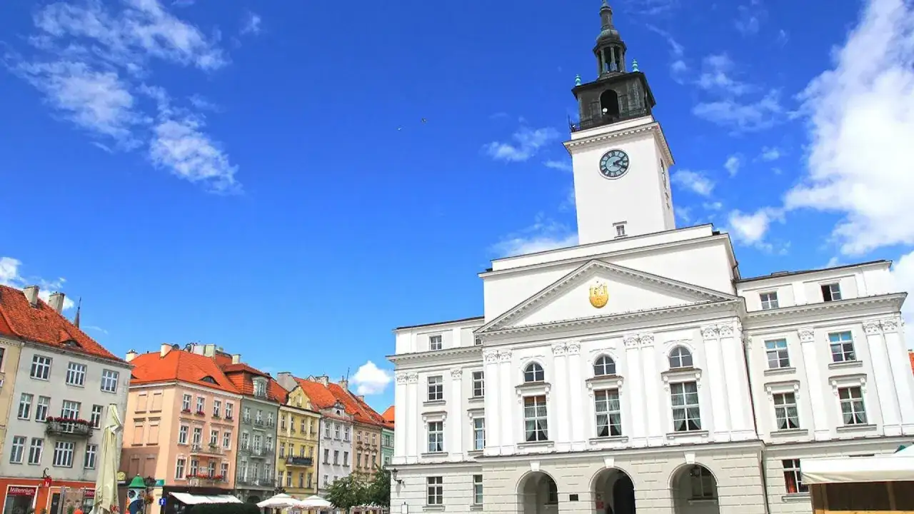Ratusz w Kaliszu, z charakterystyczną wieżą i zegarem, góruje nad kolorową zabudową rynku. To serce miasta i jedna z jego głównych atrakcji.