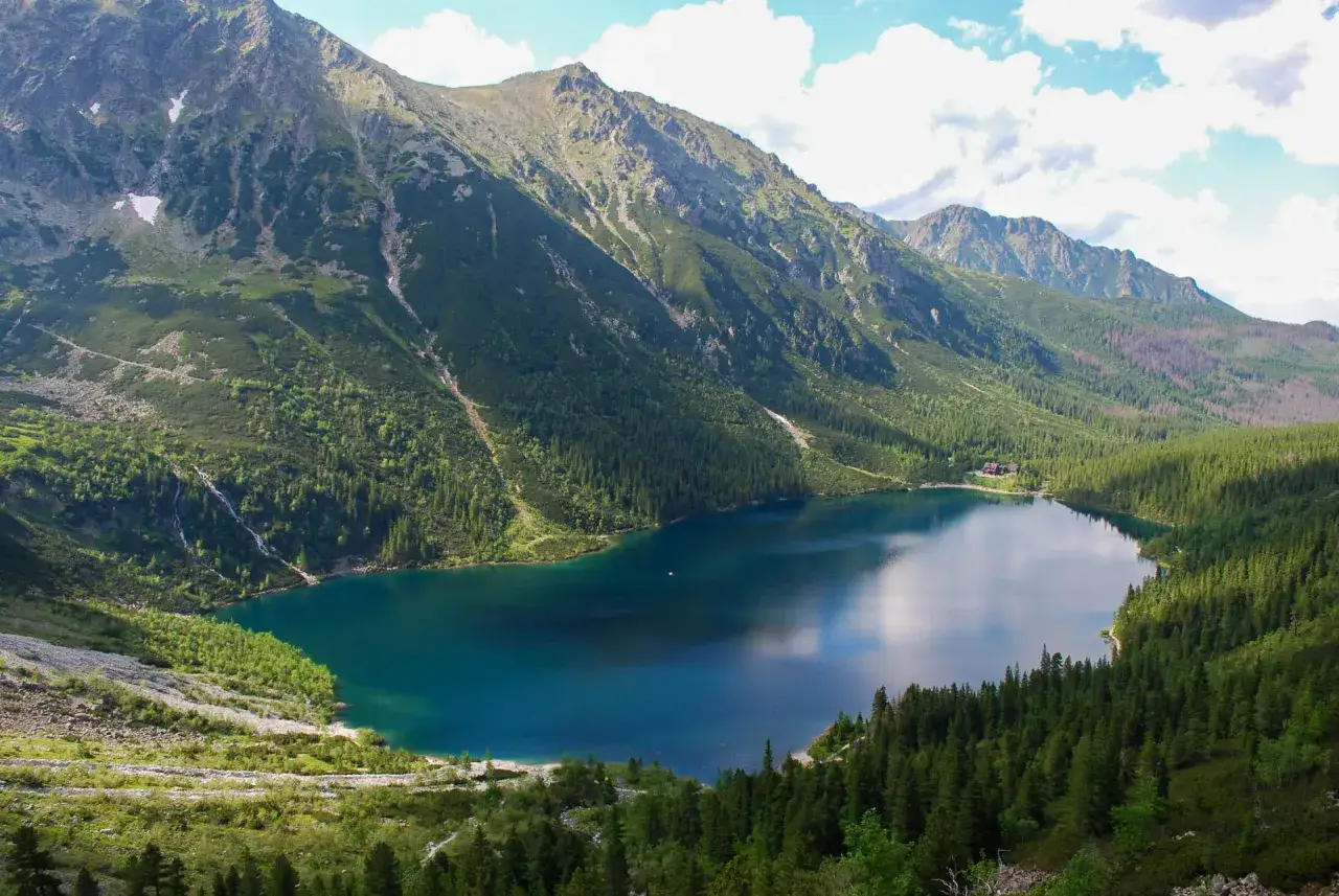 Morskie Oko, jezioro w Tatrach, otoczone zielonymi zboczami g&oacute;r. Jego wysokość nad poziomem morza to 1395 m.