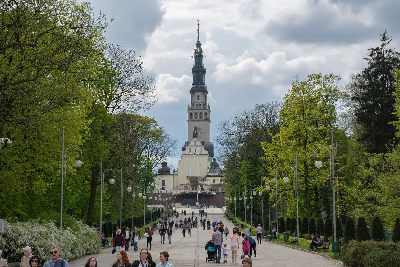 Aleja prowadząca do Jasnej G&oacute;ry w Częstochowie. Ludzie spacerują, podziwiając architekturę i zieleń.