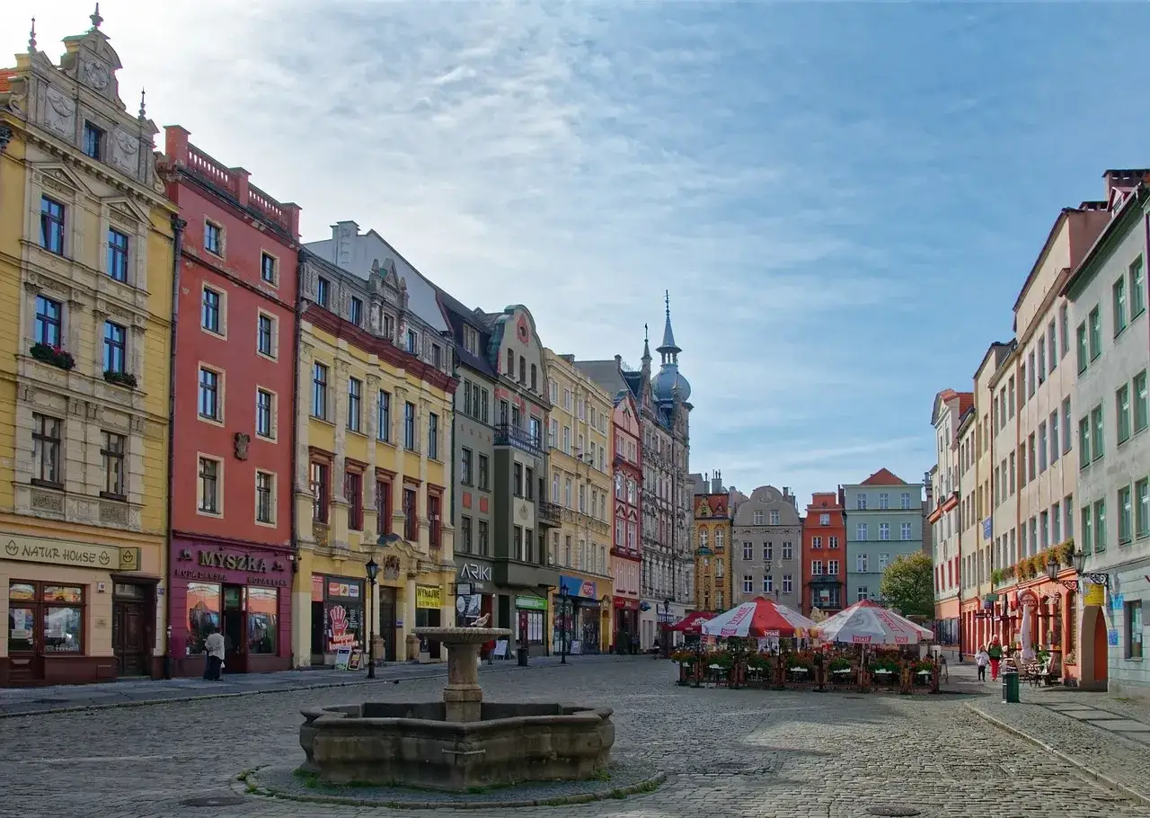 Kolorowe kamienice i fontanna na brukowanym rynku w Świdnicy. To urokliwe świdnica atrakcje, idealne na spacer.