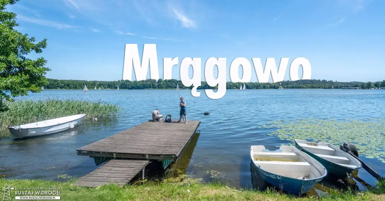 Wakacje w Mrągowie: dzieci łowią ryby z pomostu, a w tle żaglówki na jeziorze. To piękne mrągowo atrakcje.