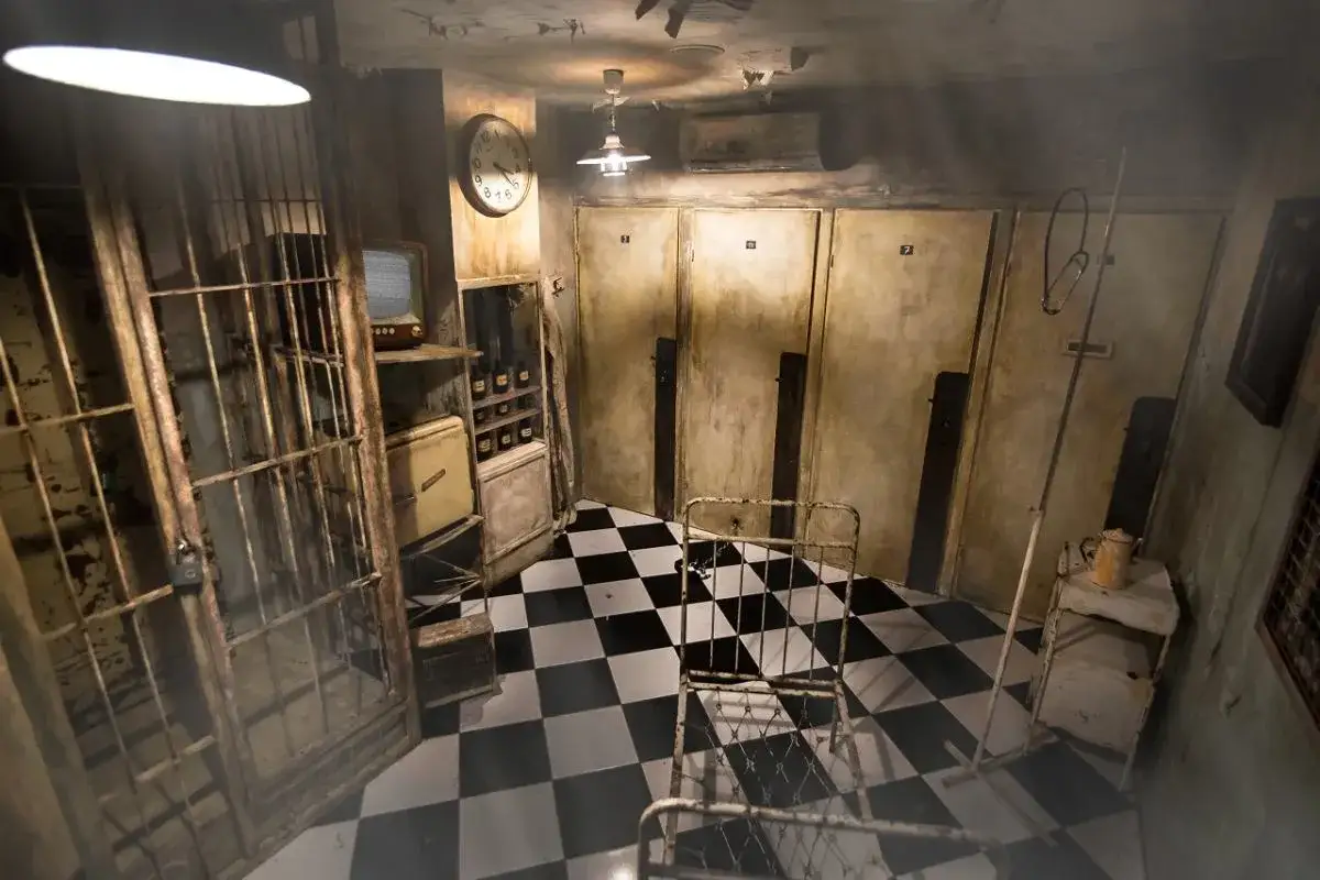 Mroczny pok&oacute;j zagadek, idealny na escape room we Wrocławiu. Kraty, stare ł&oacute;żko i tajemnicze drzwi czekają na odkrycie.