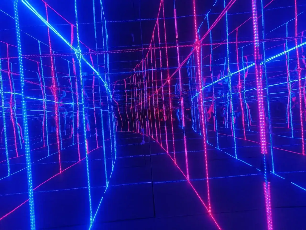Nieskończona sieć neonowych linii w muzeum światła. Błękitne i różowe światła tworzą hipnotyzującą iluzję przestrzeni.