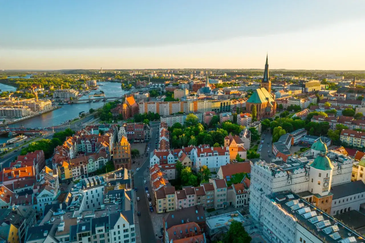Widok na miasto z rzeką i zabytkowymi kamienicami. Odkryj Szczecin i okolice atrakcje podczas słonecznego popołudnia.