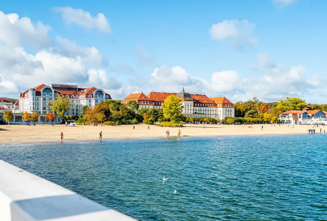 Piękne, nadmorskie miejscowości zachwycają architekturą i złotą plażą. Spacerowicze cieszą się jesiennym słońcem.