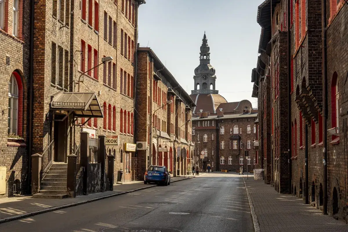 Ulica Nikiszowca w Katowicach, z charakterystyczną architekturą i wieżą kościoła. To jedne z najciekawszych katowickich atrakcji.