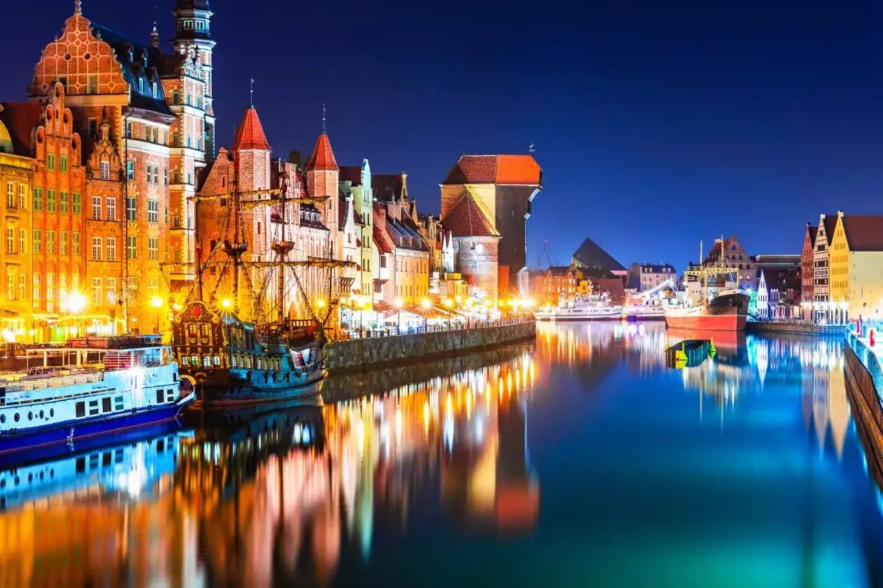 Gdańsk nocą: zabytkowe kamienice, żaglowiec i statki tworzą niepowtarzalny klimat. Idealne miejsce na wieczorne spacery i odkrywanie atrakcji dla dorosłych.
