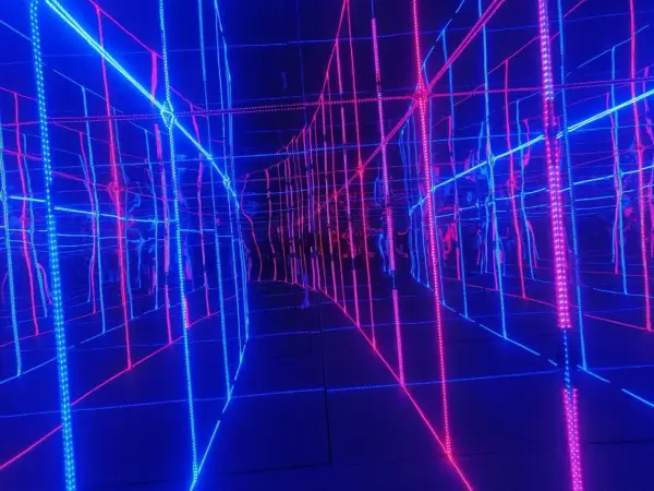 Nieskończona sieć neonowych linii w muzeum światła, tworząca iluzję przestrzeni.